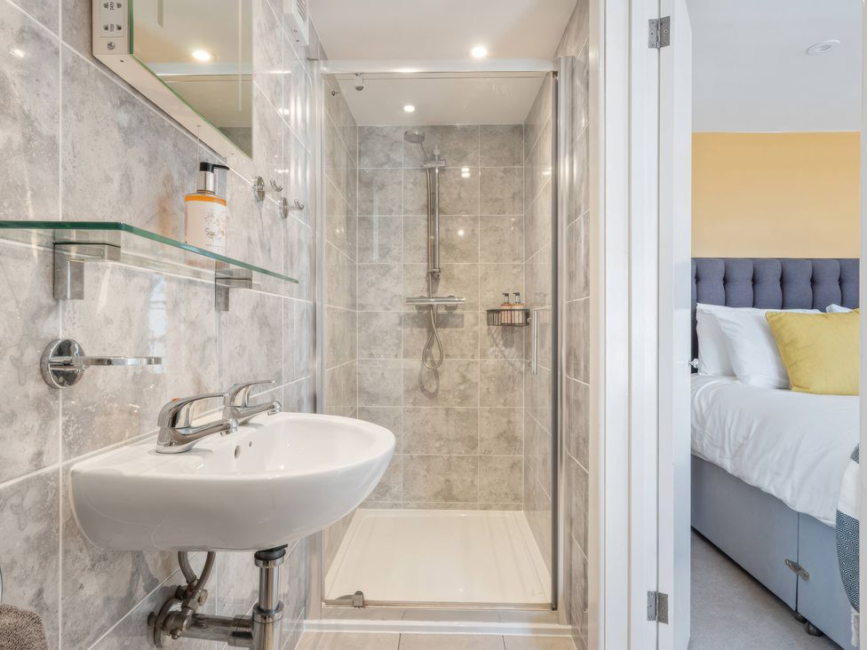 A bathroom with shower and sink at TBC