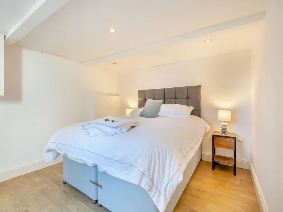 A bedroom with a bed and bedside table at TBC