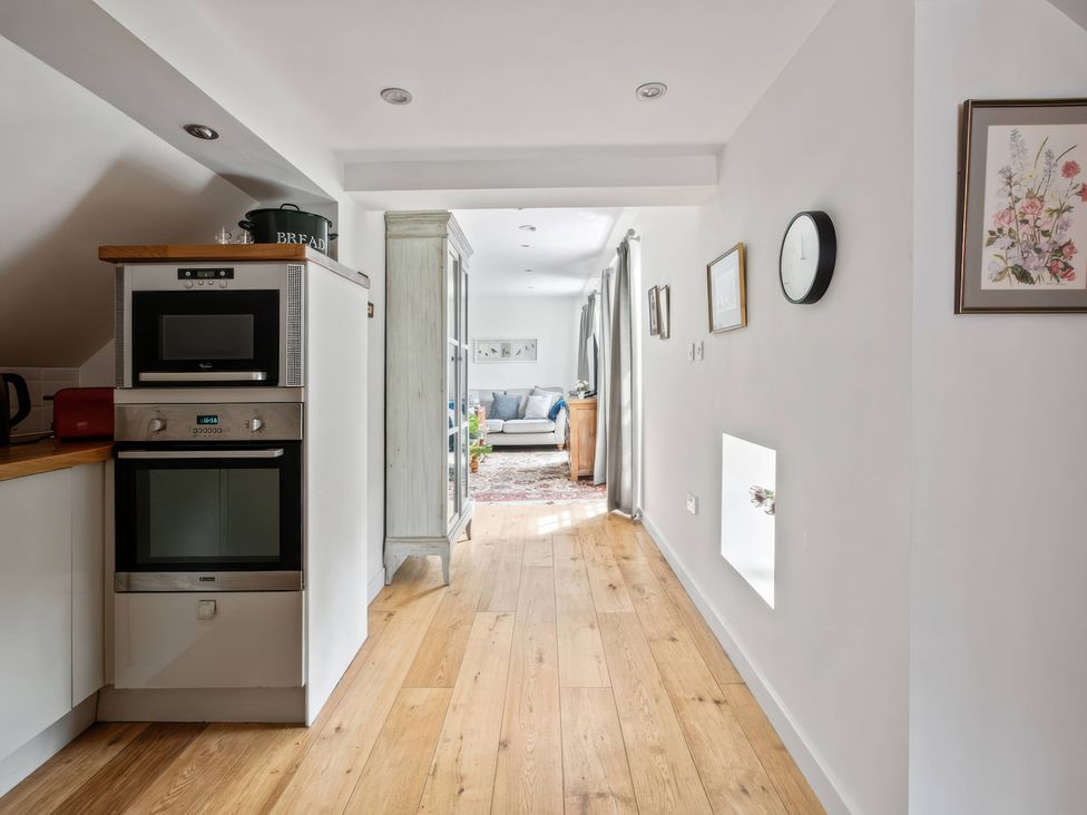 A kitchen with appliances and a view to the living area at The Old Barn in 