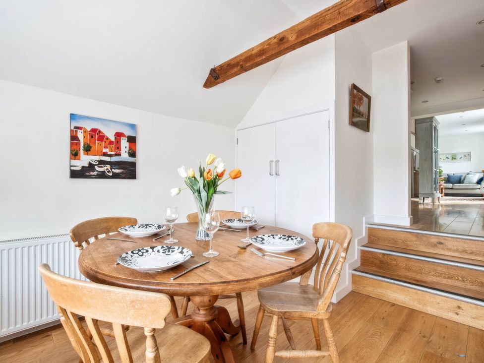 A dining room with a wooden table and chairs at TBC 