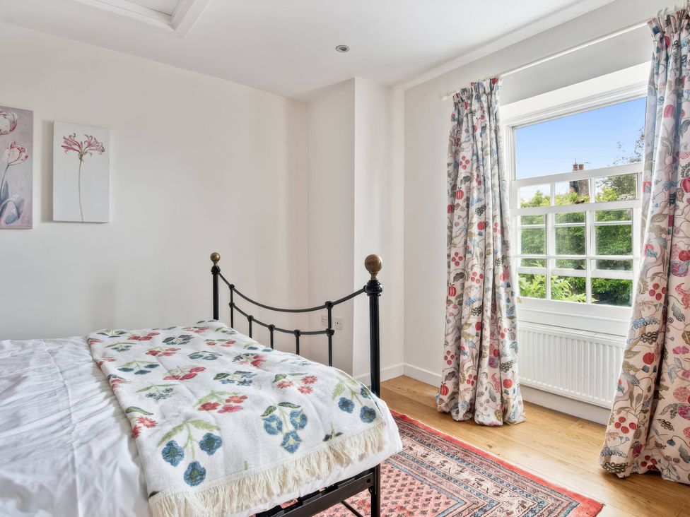 A bedroom with a bed, curtains, and window at TBC