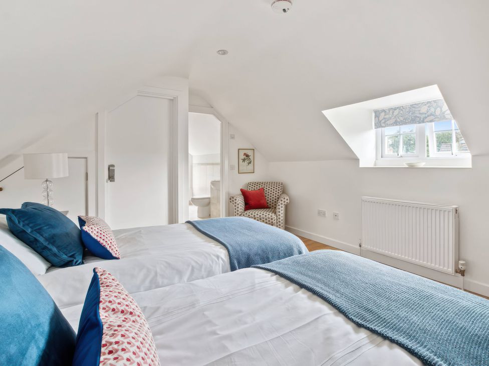 A bedroom with two beds and a chair at TBC in 