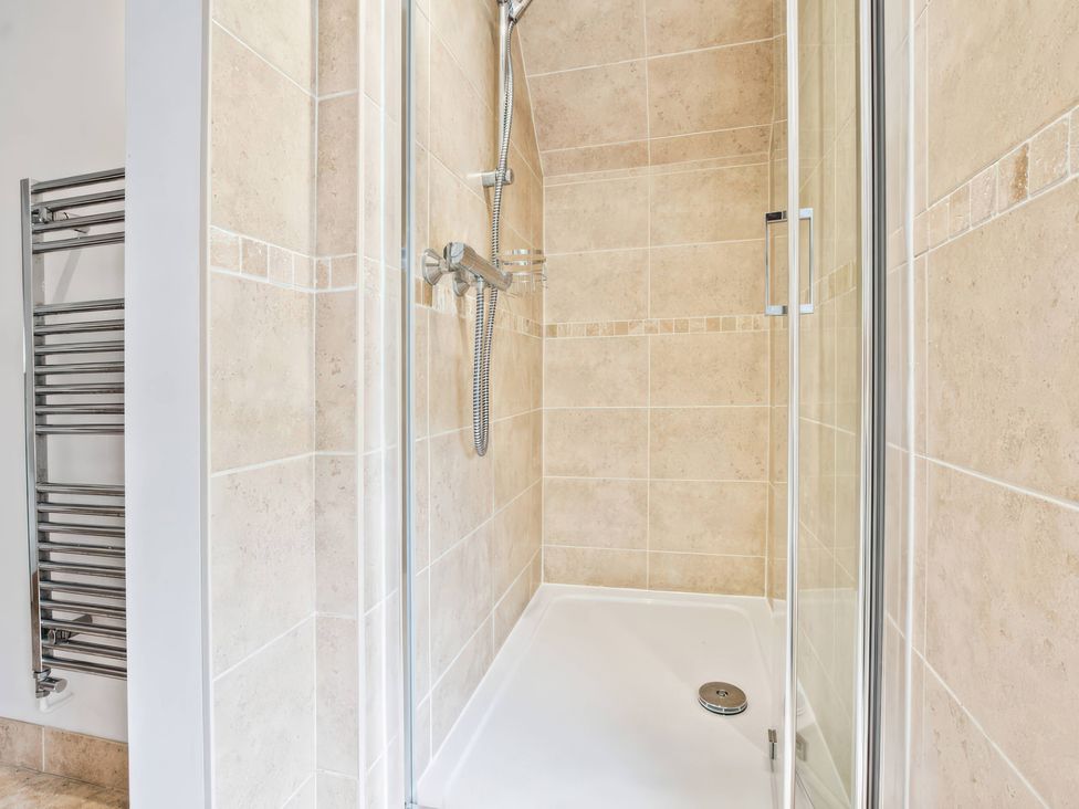 A shower with tiled walls and a towel rail at TBC 