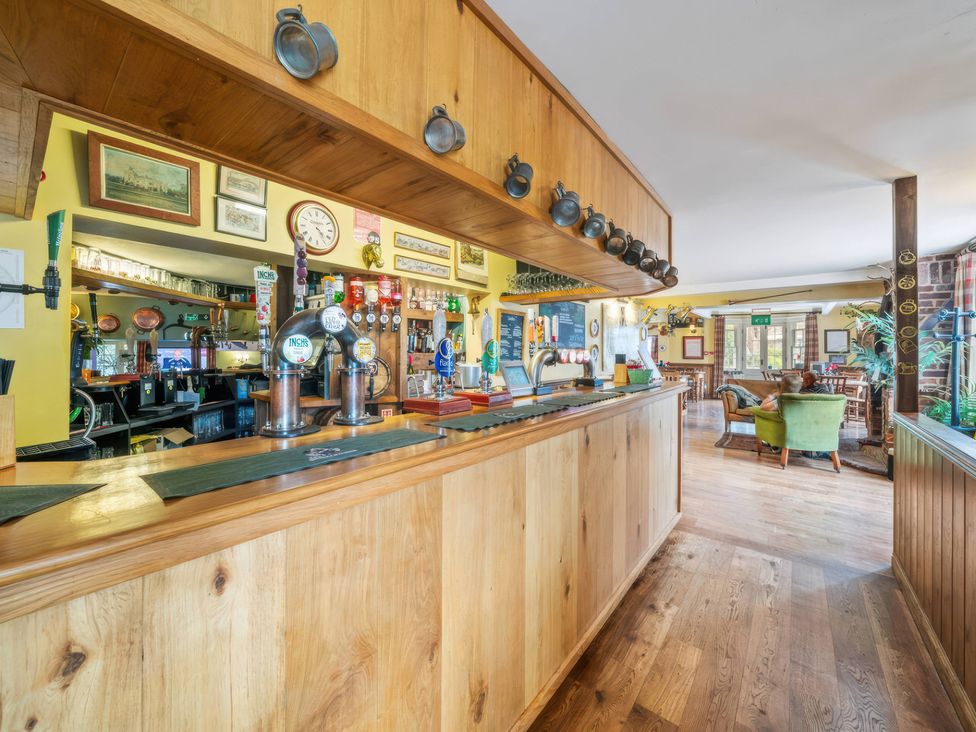A bar area with beer taps and seating at TBC