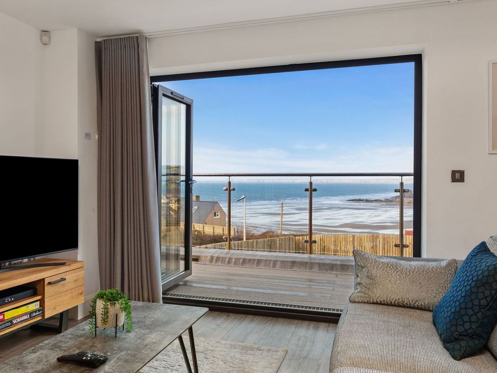 A living room with a view of the sea at One Sand Banks in Haverfordwest