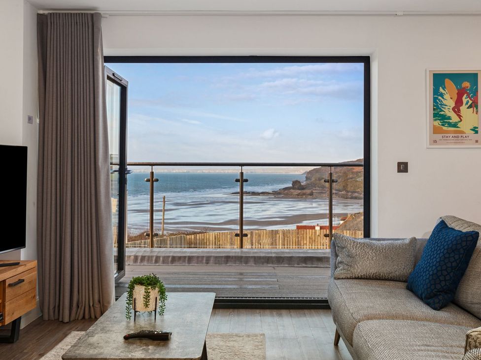 A living room with a view of the sea at One Sand Banks in Haverfordwest