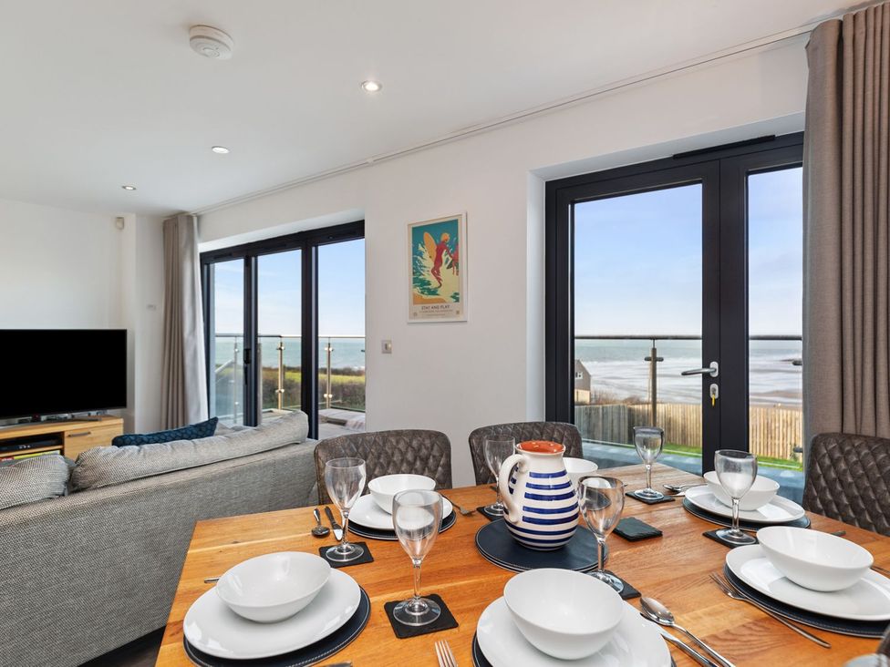 A dining room with a table set for a meal at One Sand Banks in Haverfordwest