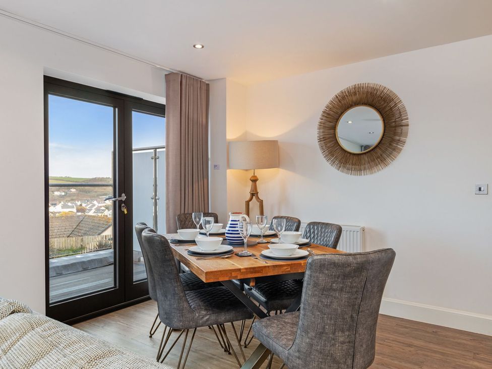 A dining room with a table and glassware at One Sand Banks in Haverfordwest