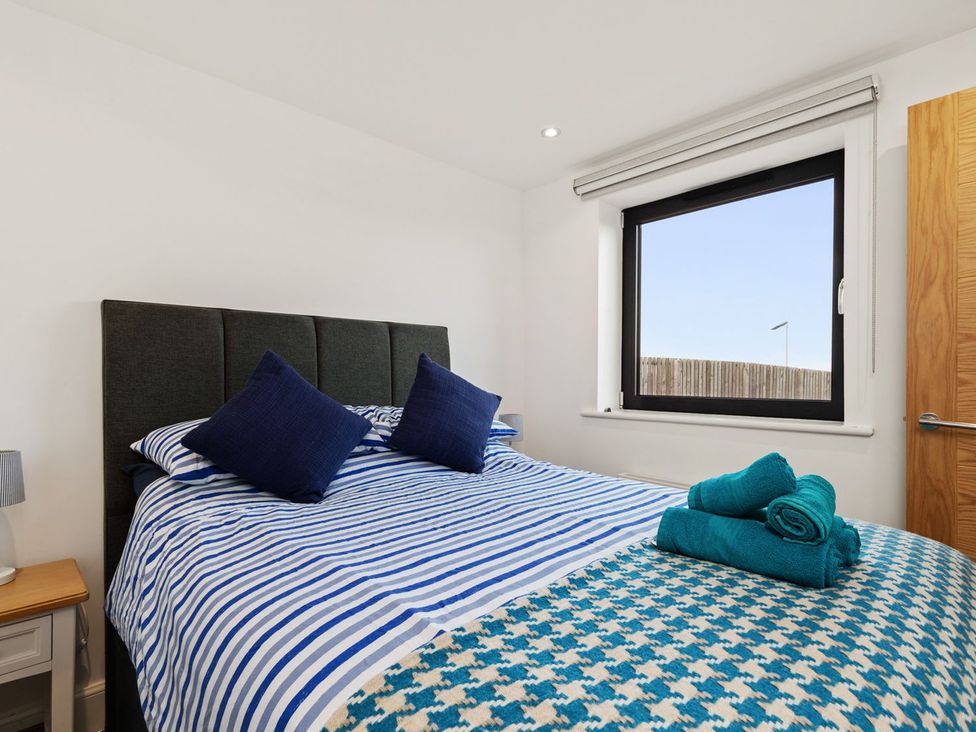 A bedroom with a bed and towels at One Sand Banks in Haverfordwest