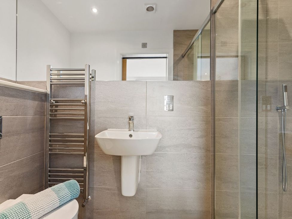 A bathroom with a washbasin and shower at One Sand Banks in Haverfordwest