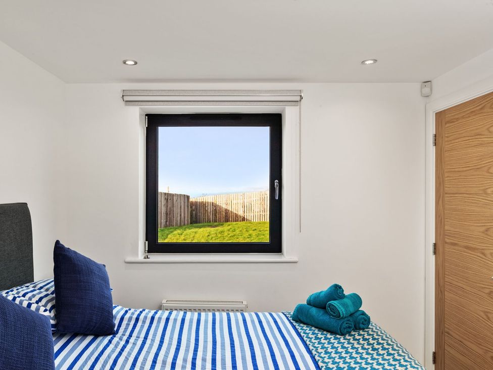 A bedroom with a bed and window at One Sand Banks in Haverfordwest