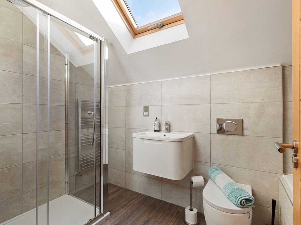 A bathroom with a shower and toilet at One Sand Banks in Haverfordwest