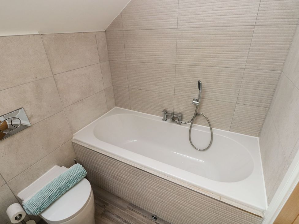 A bathroom with a bathtub and toilet at One Sand Banks in Haverfordwest