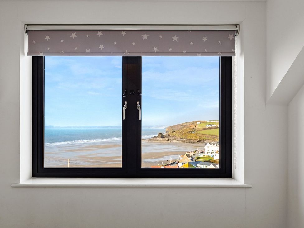 A window view of beach and ocean at One Sand Banks in Haverfordwest