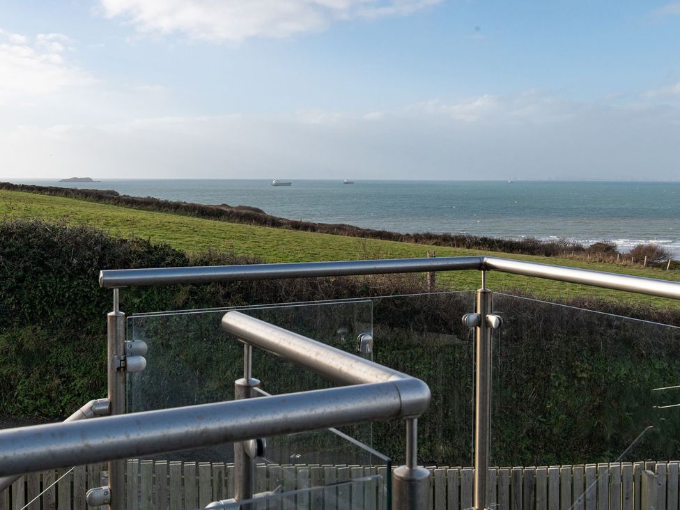 A viewpoint overlooking the ocean and grassy land at One Sand Banks in Haverfordwest