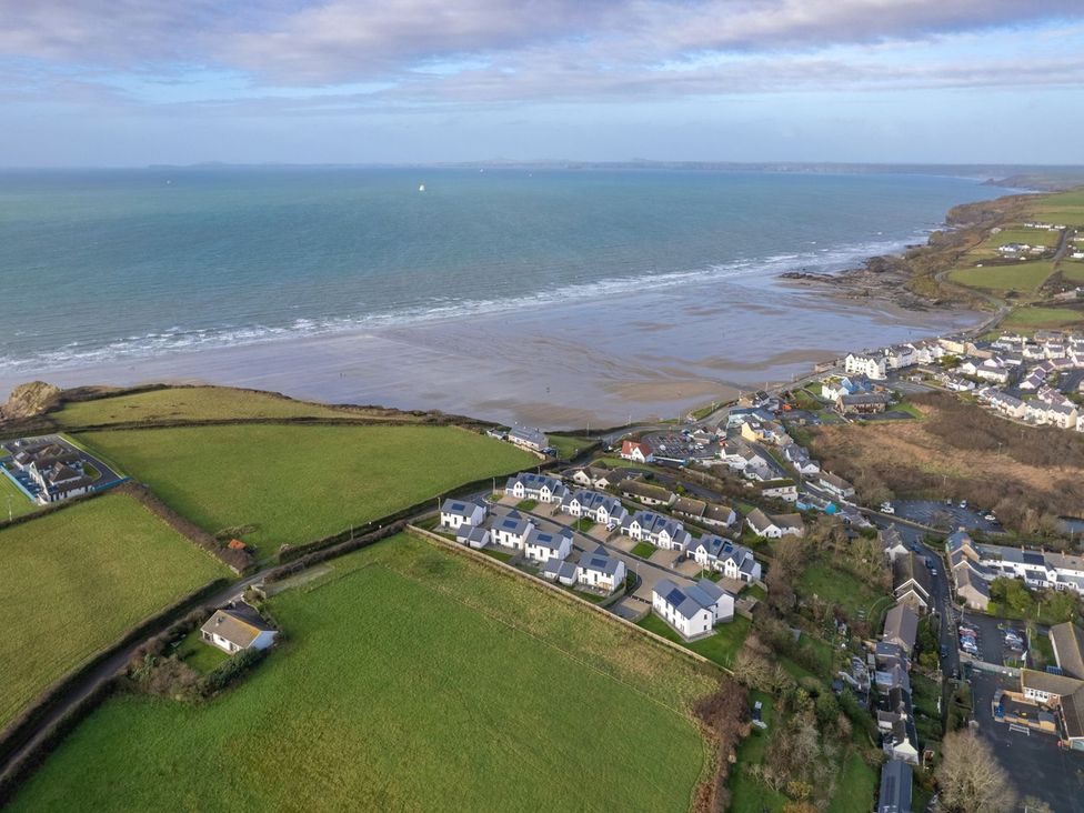An aerial view of a beach and coastal houses at One Sand Banks in Haverfordwest