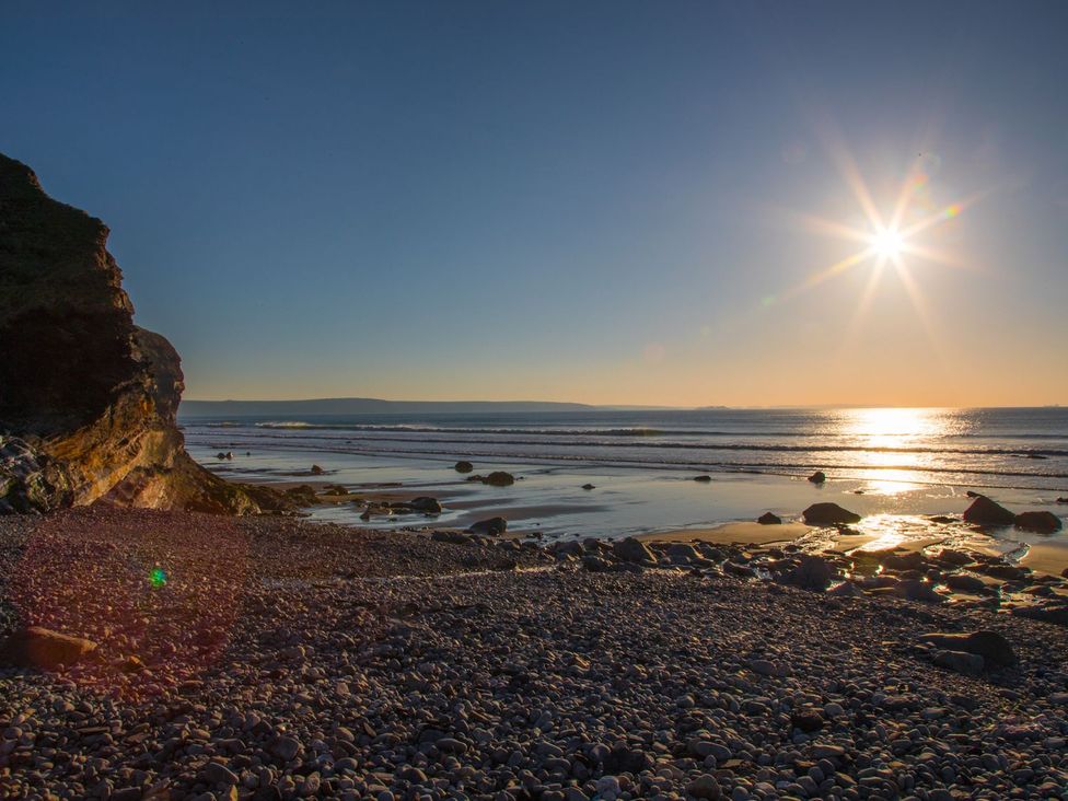 A beach scene with rocks and sun at One Sand Banks, Haverfordwest