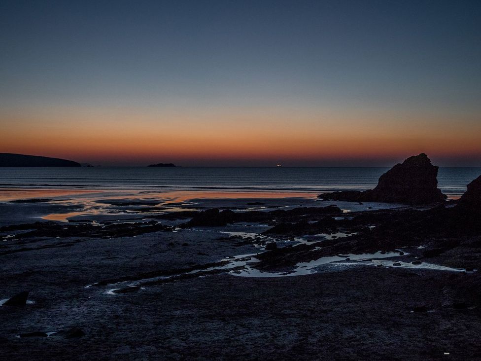 A beach with rocks and a calm sea at One Sand Banks in Haverfordwest