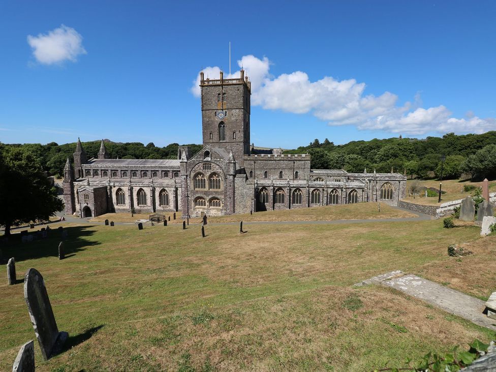 A church building with a tower and grave markers at One Sand Banks in Haverfordwest