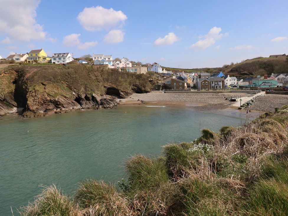 A beach area with water and houses at One Sand Banks in Haverfordwest