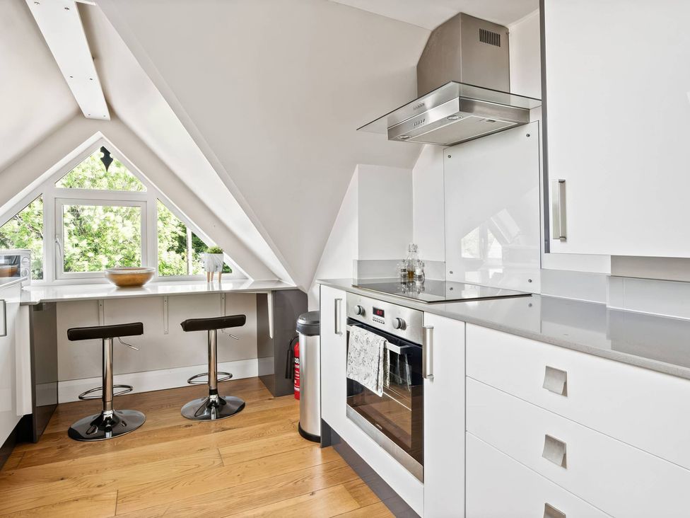 A kitchen with bar stools and a window at TBC in 