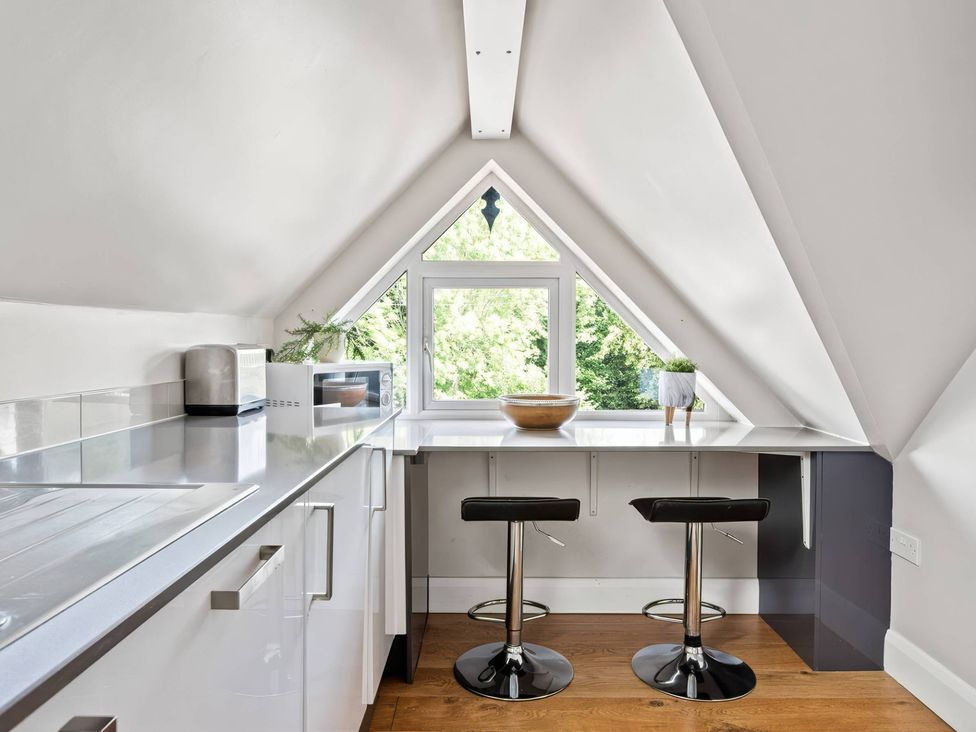 A kitchen with a counter and stools at TBC in 