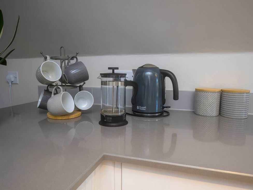 A kitchen counter with a kettle, mugs, and a French press at TBC 