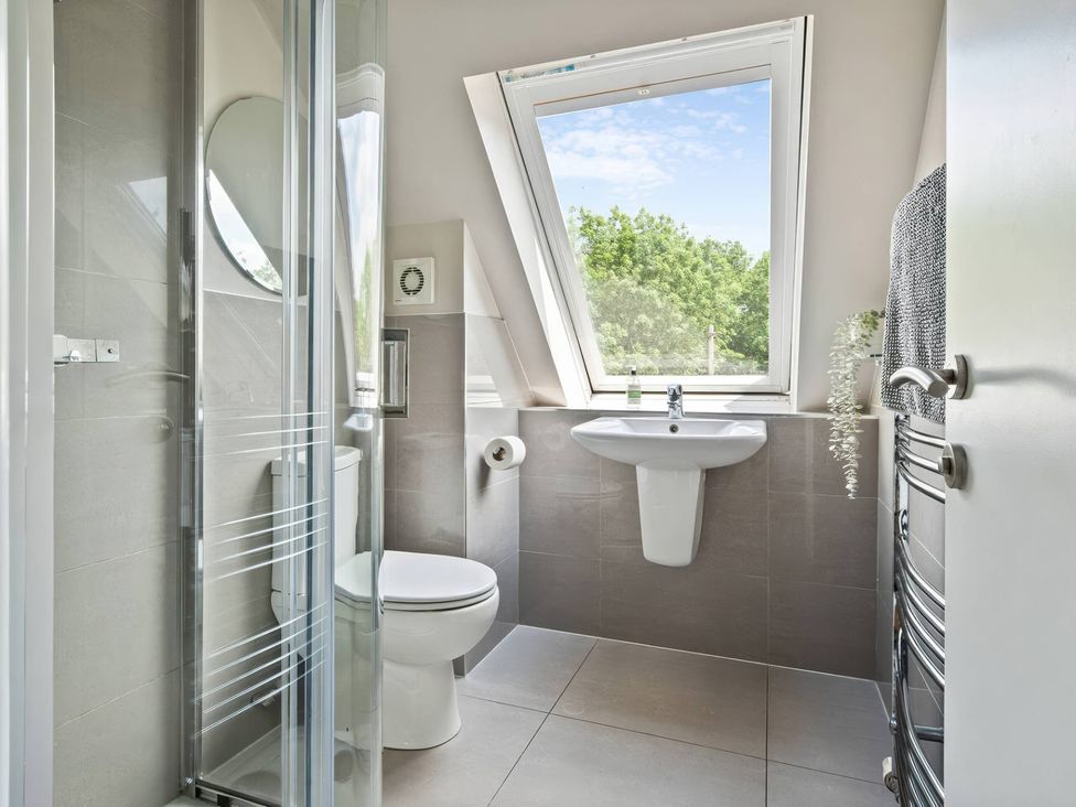 A bathroom with a shower, toilet, and sink at TBC 
