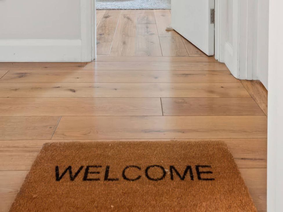 An entrance with a welcome mat on the floor at TBC