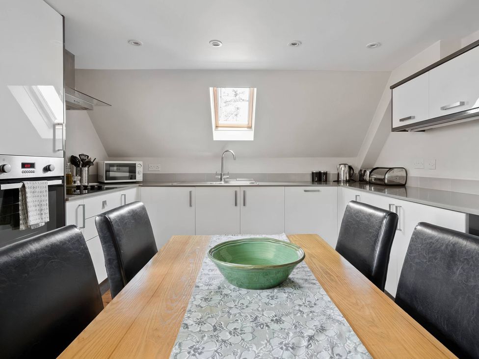 A kitchen with appliances and a dining table at TBC