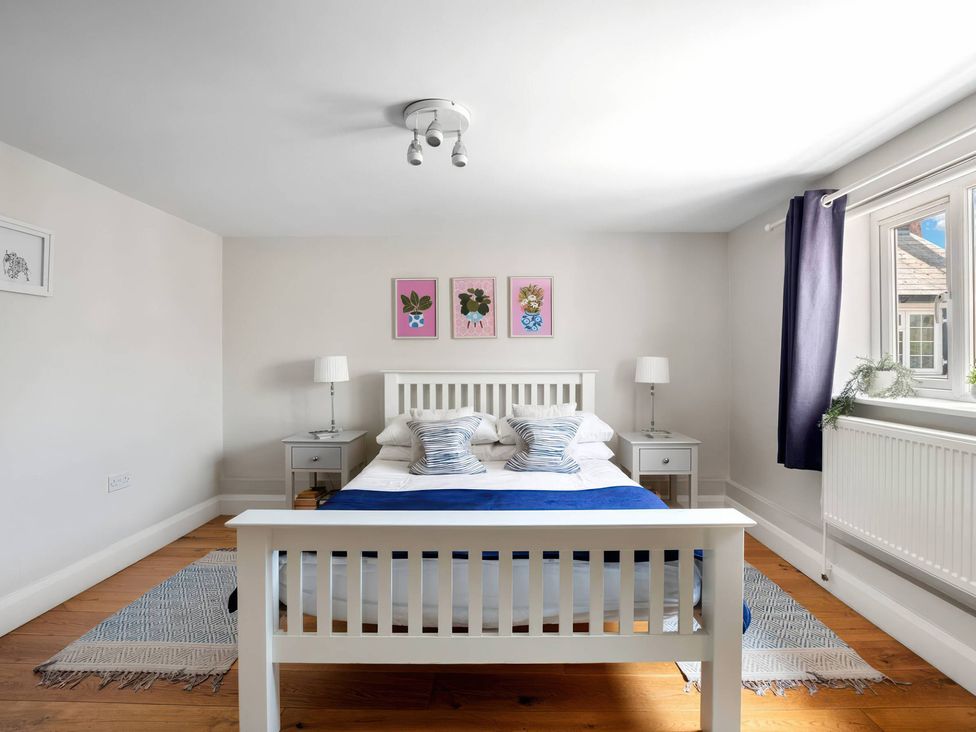 A bedroom with a bed and nightstands at TBC