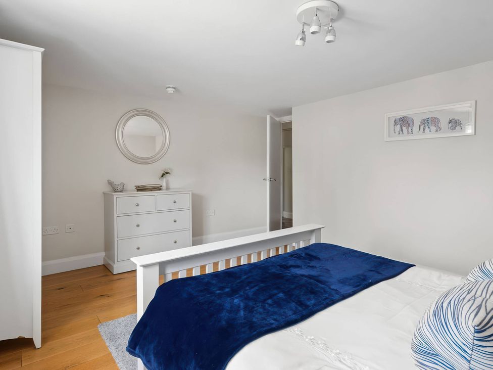 A bedroom with a bed and dresser at TBC