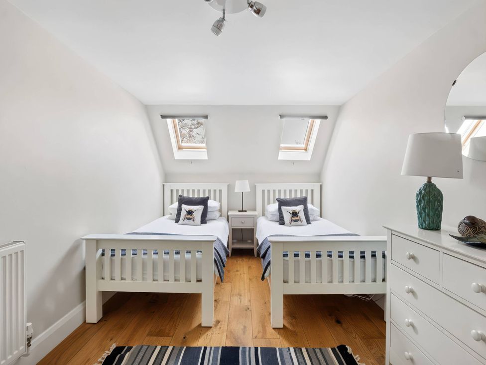 A bedroom with two beds and a dresser at TBC
