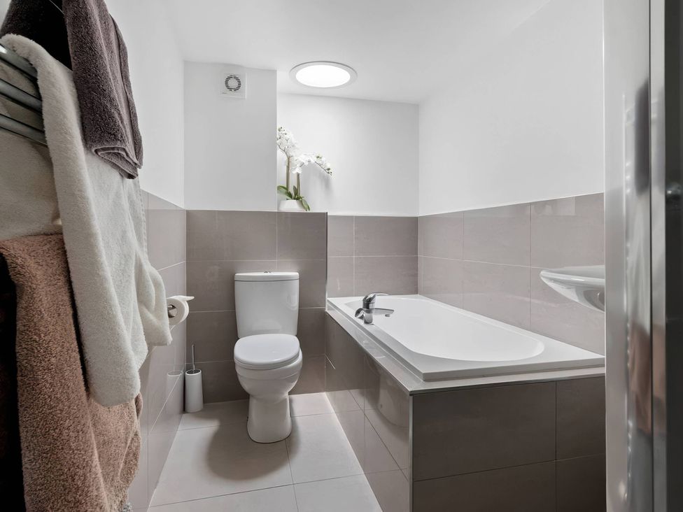 A bathroom with a toilet, sink, and bathtub at TBC