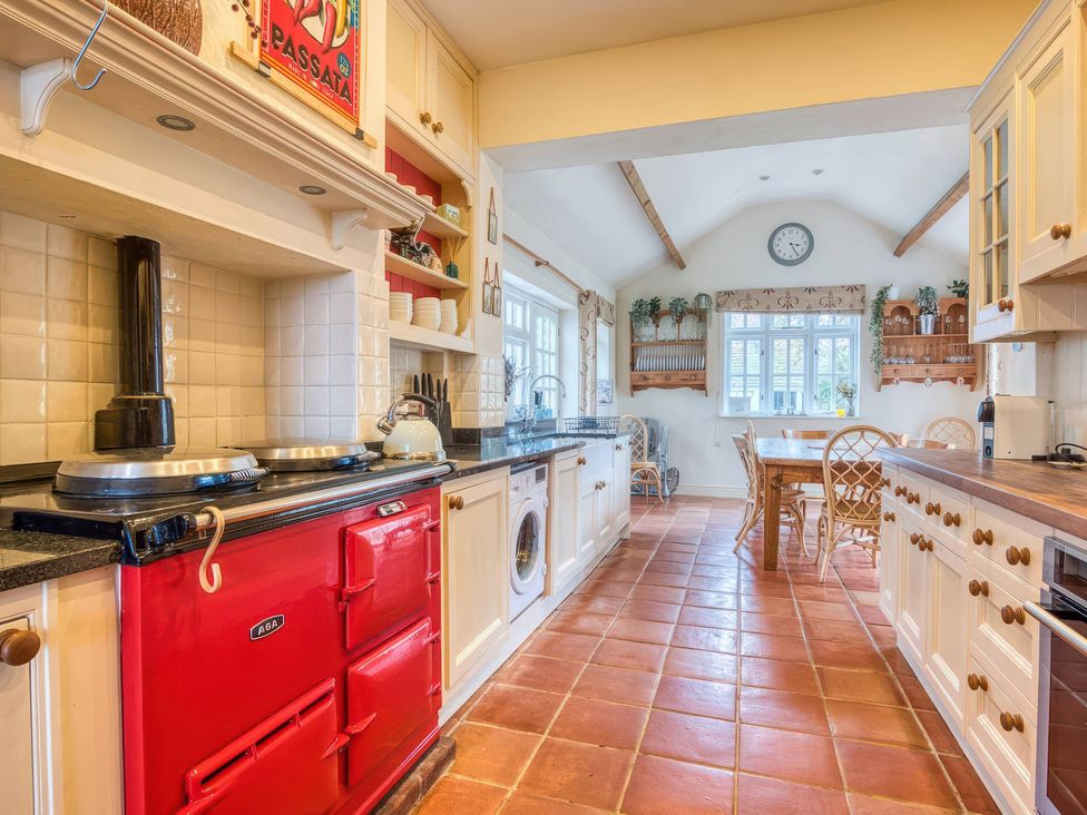 A kitchen with a red stove and wooden table at The Old Barn in Manchester