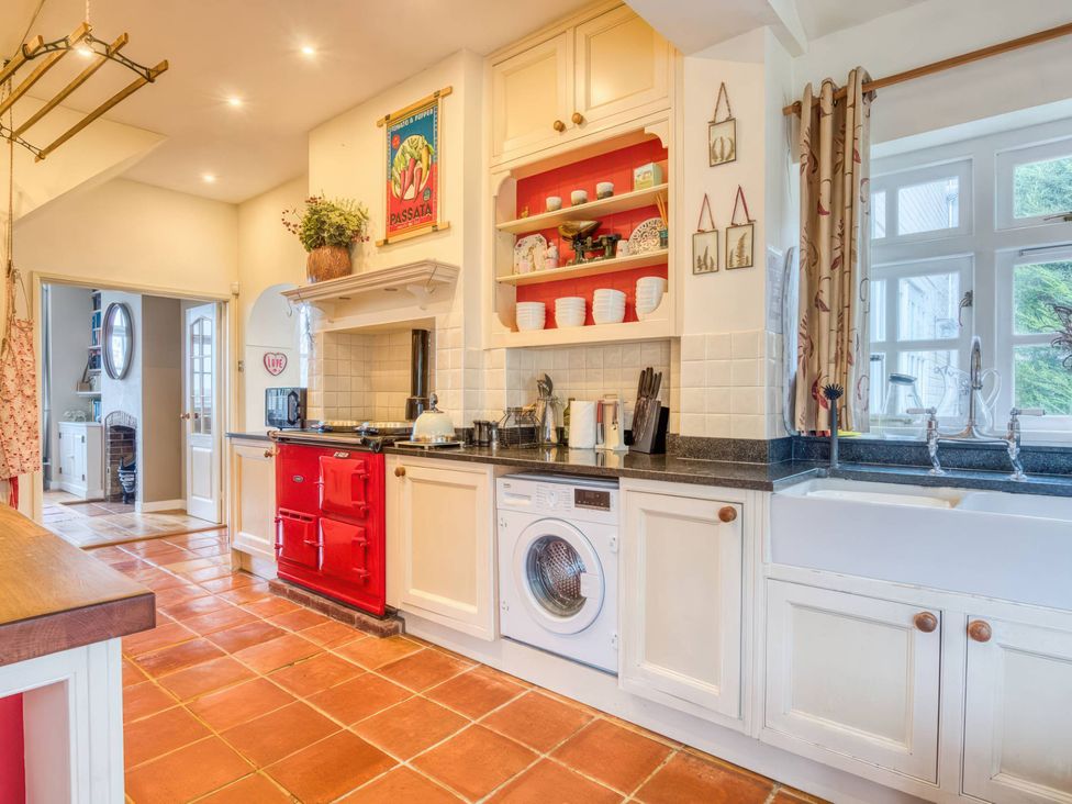A kitchen with red appliances and white cabinetry at The Old Barn in 