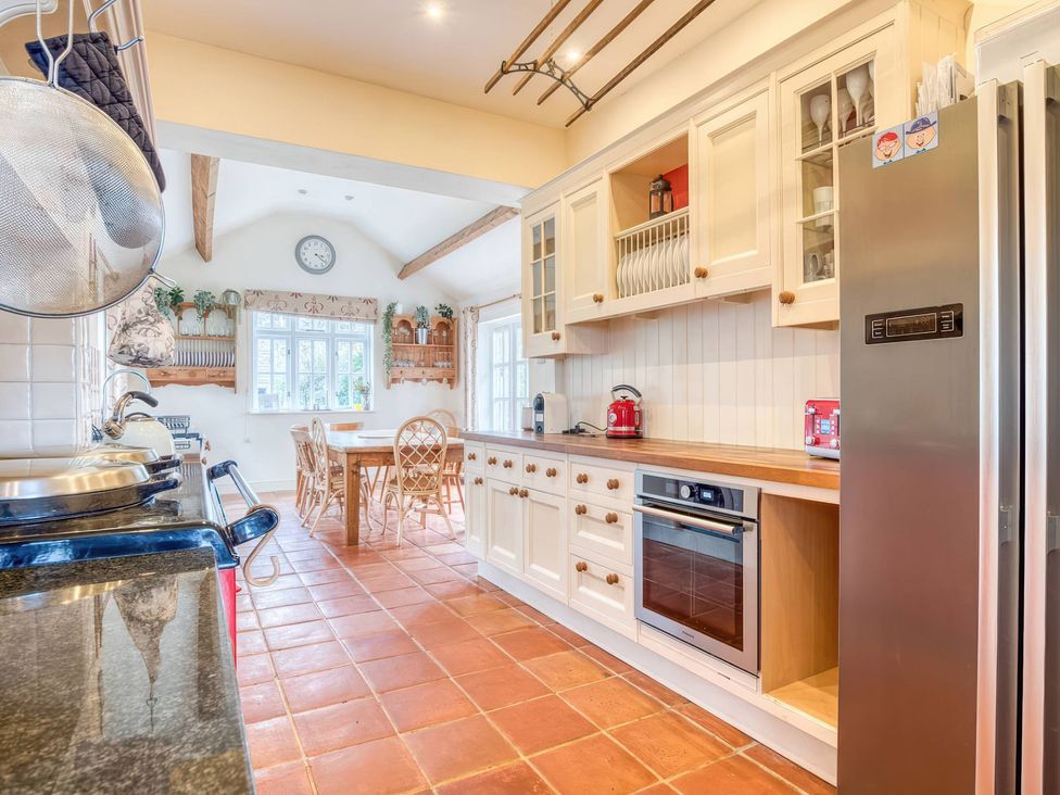 A kitchen with cabinets and a dining table at TBC in 
