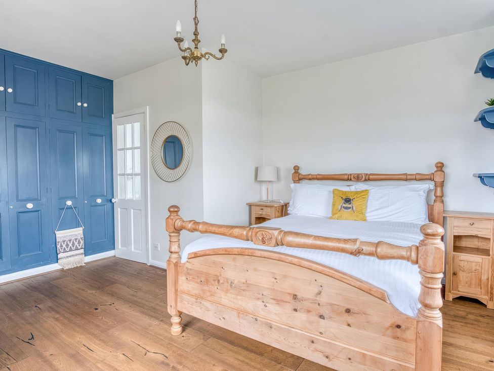 A bedroom with a bed and wardrobe at TBC