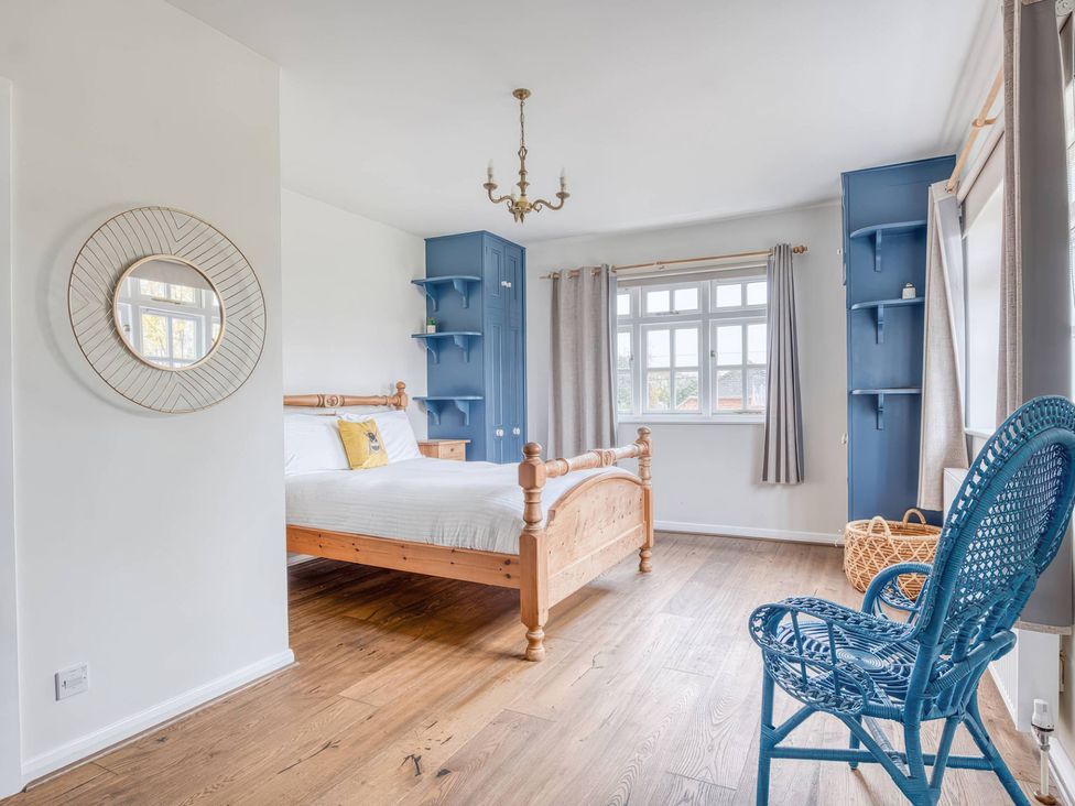 A bedroom with a bed and a chair at TBC