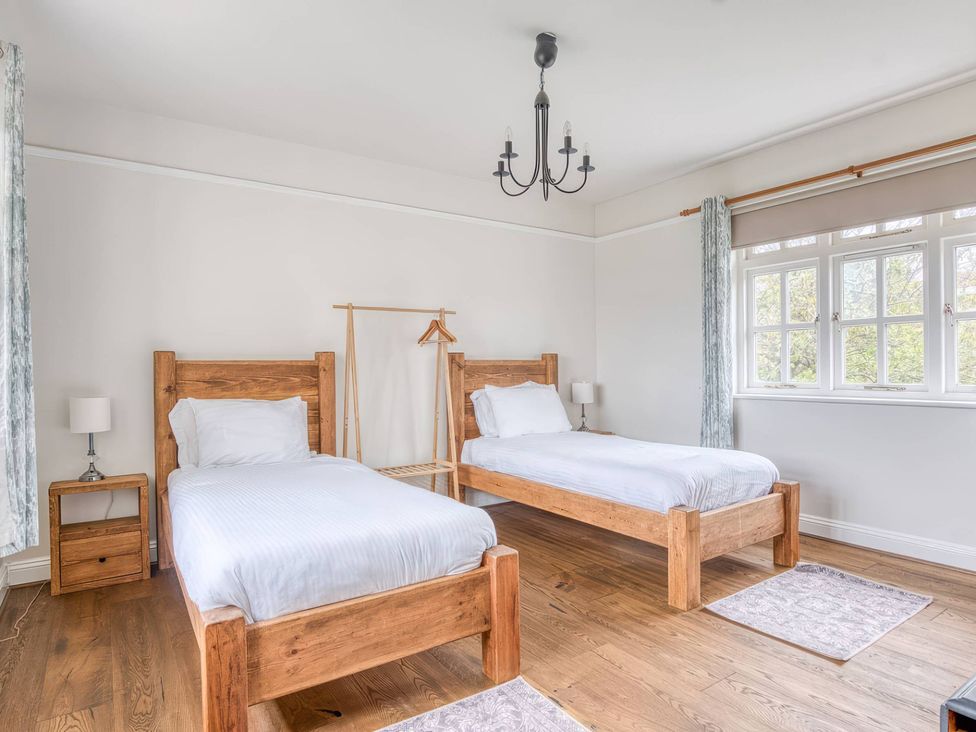 A bedroom with two beds and a clothes rack at TBC 