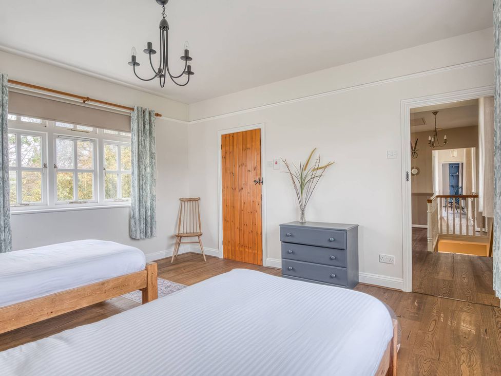 A bedroom with two beds and a window at TBC