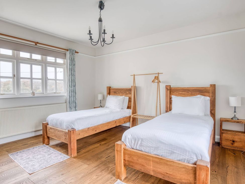 A bedroom with two single beds and a clothes rack at TBC in 
