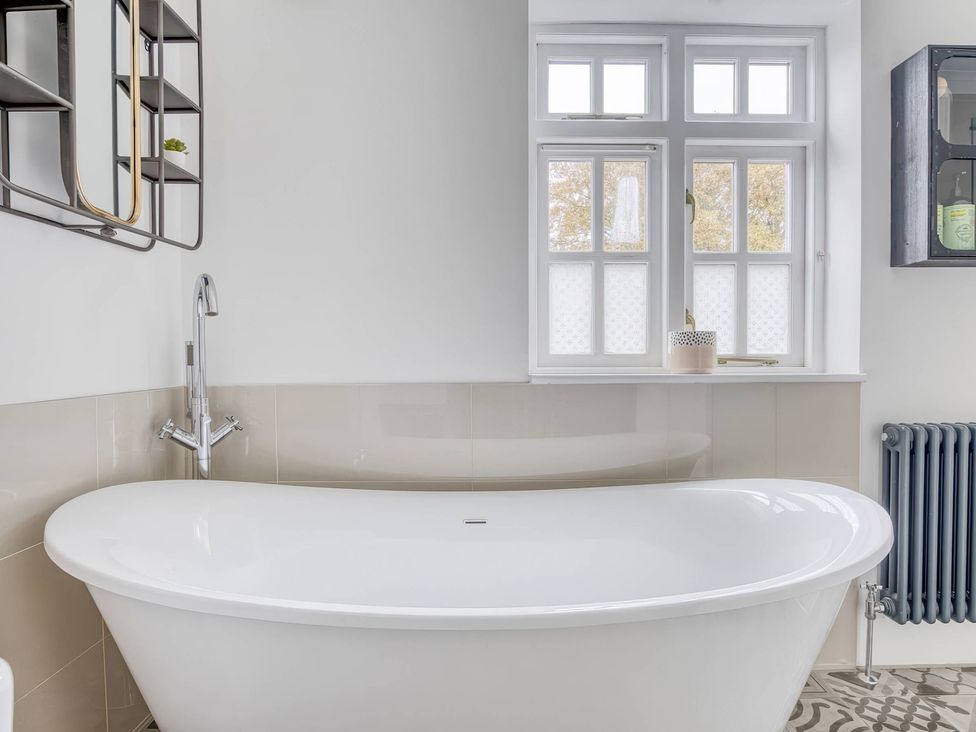 A bathroom with a freestanding bathtub and a window at TBC