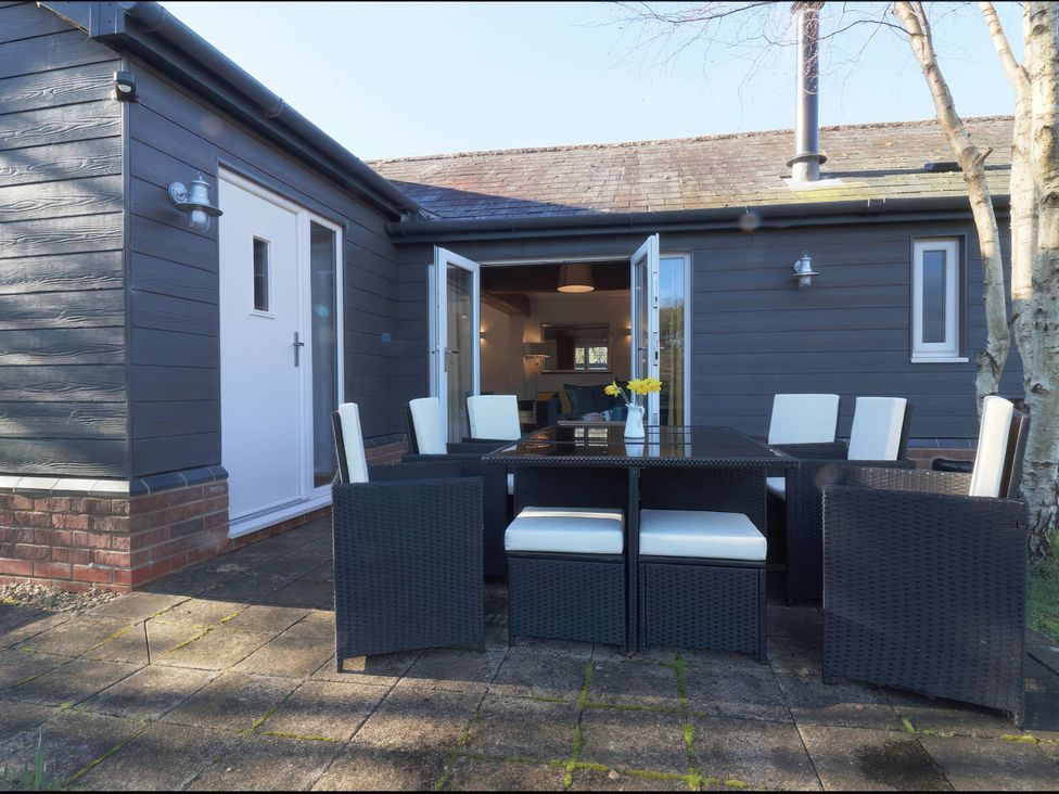 An outdoor area with a table and chairs at TBC in 