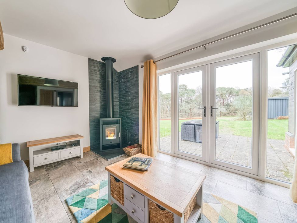 A living room with a fireplace and glass doors at TBC