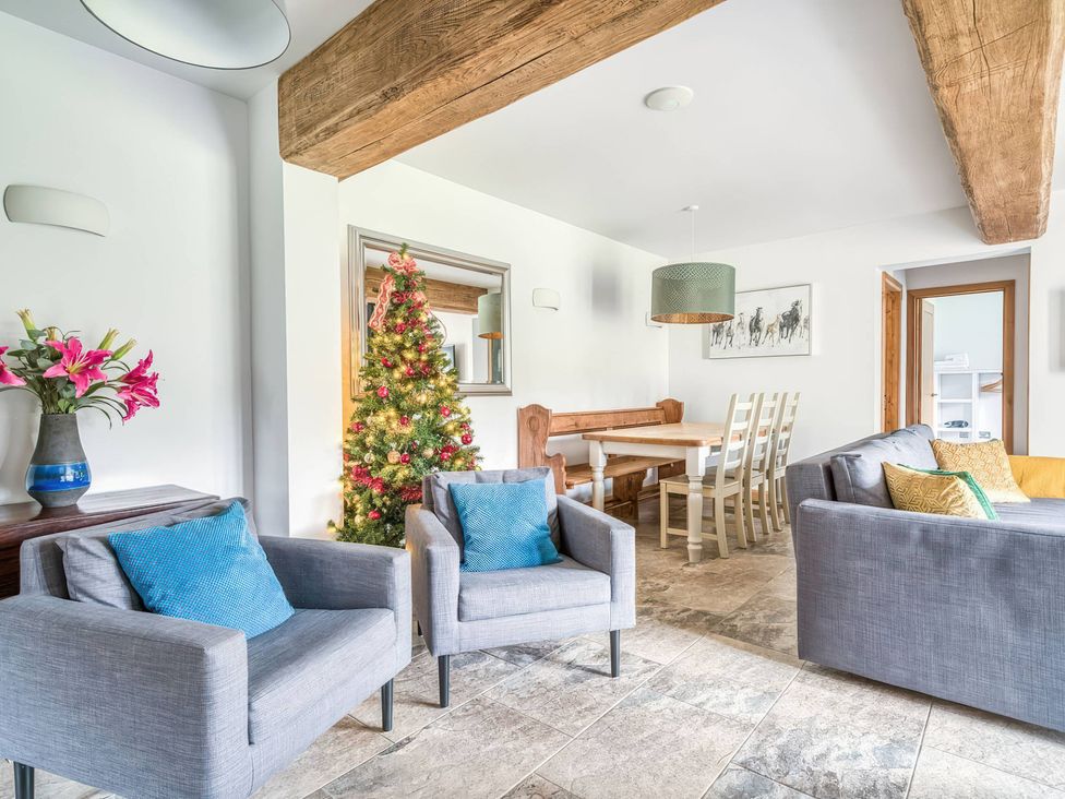 A living room with a Christmas tree and dining area at TBC 