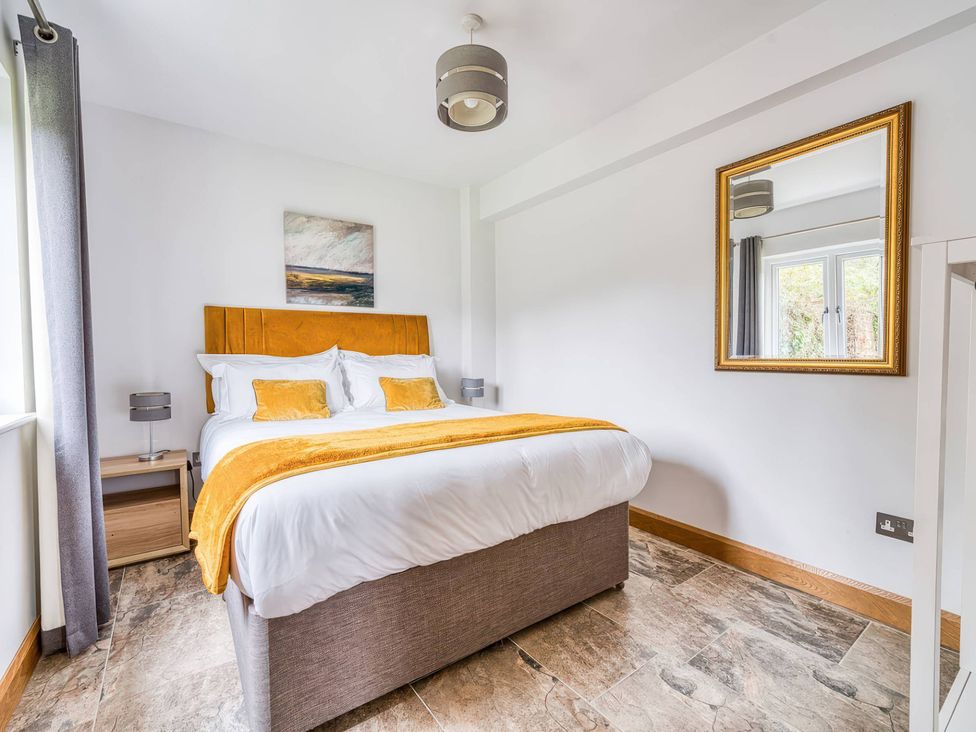 A bedroom with a bed and nightstand at TBC