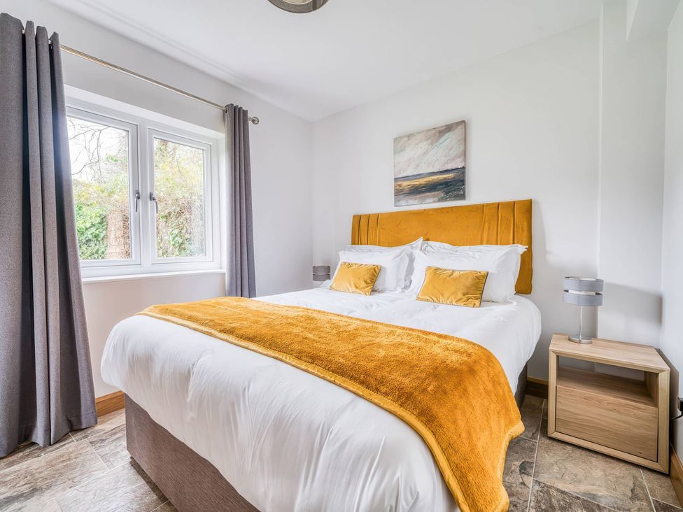 A bedroom with a bed and nightstand at TBC