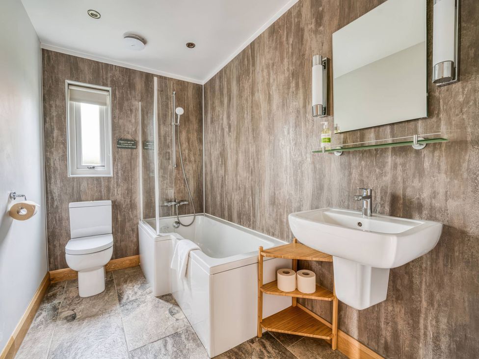 A bathroom with a bathtub, toilet, sink, and shower at TBC in 