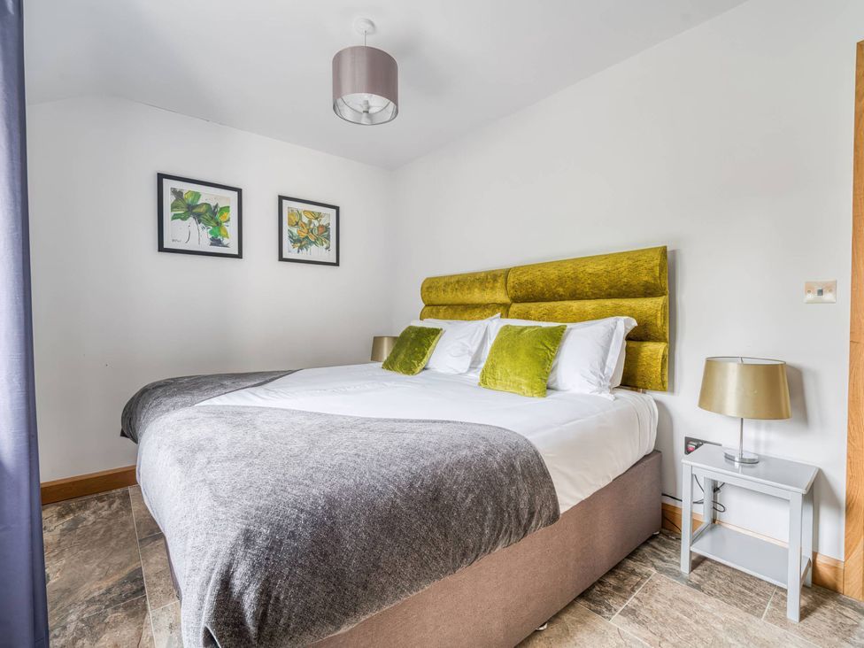 A bedroom with a bed and nightstand at TBC
